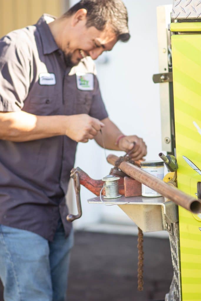 Technician working with copper pipes outdoors