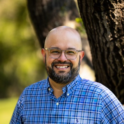 Smiling bald man with glasses outdoors