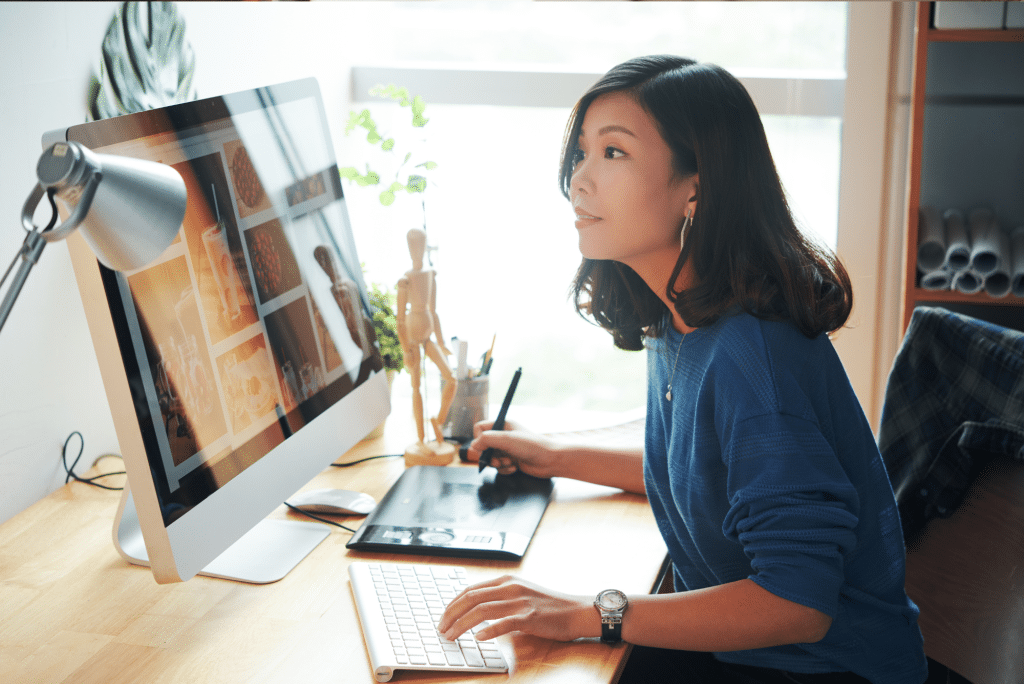 Woman using drawing tablet at desktop computer