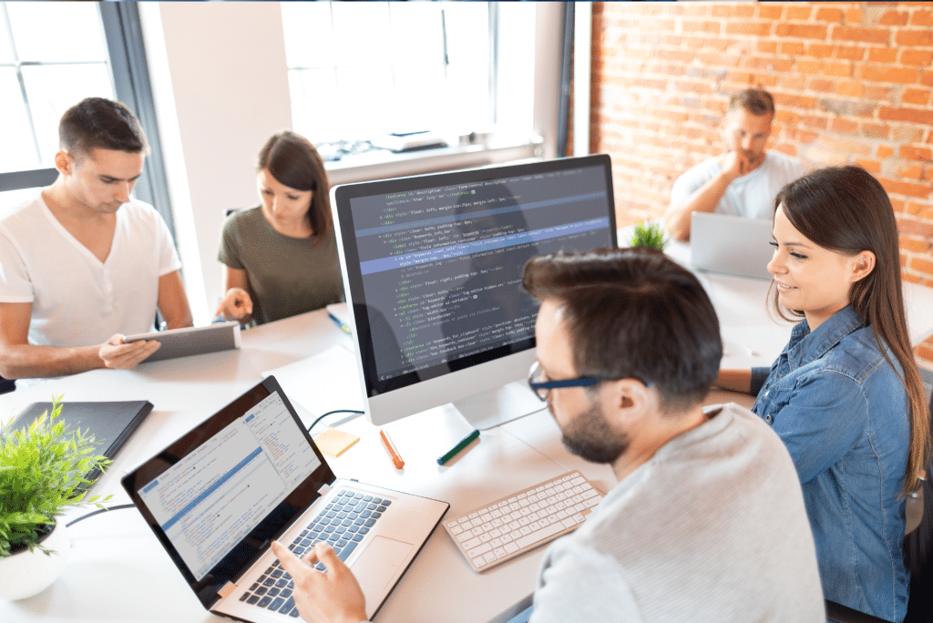 Team collaborating on coding project in modern office