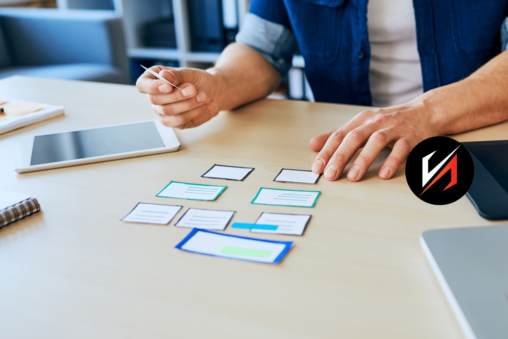Designer arranging paper wireframes on desk